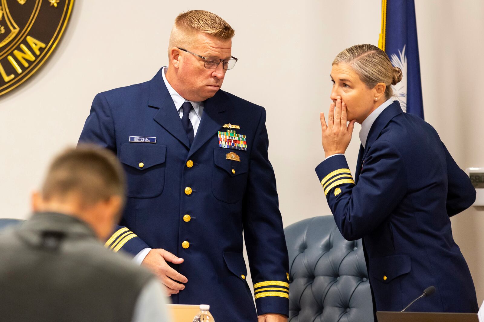 Coast Guard's Thomas Whalen, left, speaks with Nicole Emmons, right, during a break for the Titan marine board formal hearing inside the Charleston County Council Chambers, Monday, Sept. 16, 2024, in North Charleston, S.C. (AP Photo/Mic Smith)