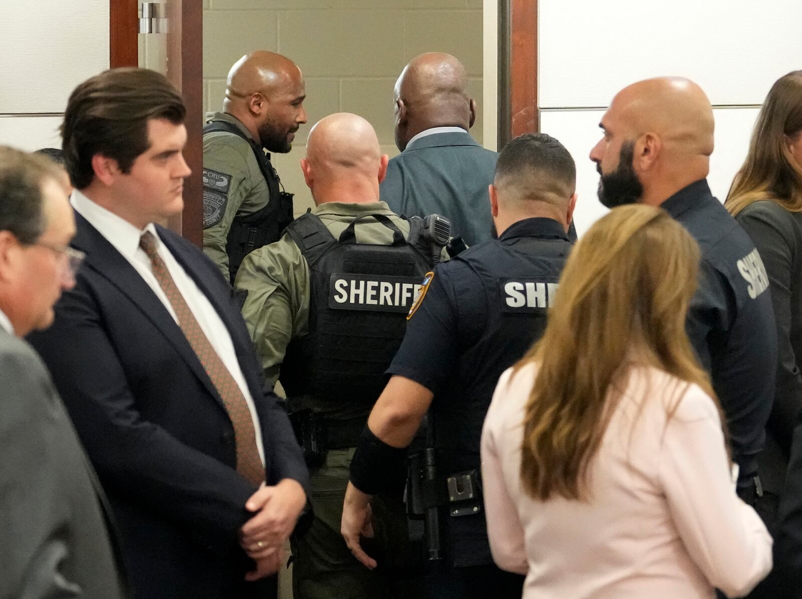 Former Houston police officer Gerald Goines, rear, is surrounded by officers as he is taken into the holding area after the guilty verdict in his murder trial in the 482nd District Court at the Harris County Criminal courthouse Wednesday, Sept. 25, 2024, in Houston. A jury found Goines guilty of two counts of murder in the January 2019 deaths of Dennis Tuttle and his wife Rhogena Nicholas. (Melissa Phillip/Houston Chronicle via AP, Pool)