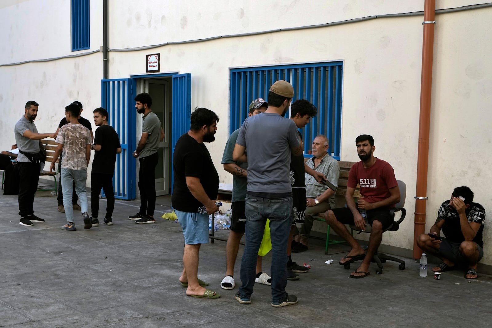 Displaced people sit in a school yard in Beirut, after fleeing the Israeli airstrikes in the south, Thursday, Sept. 26, 2024. (AP Photo/Bilal Hussein)