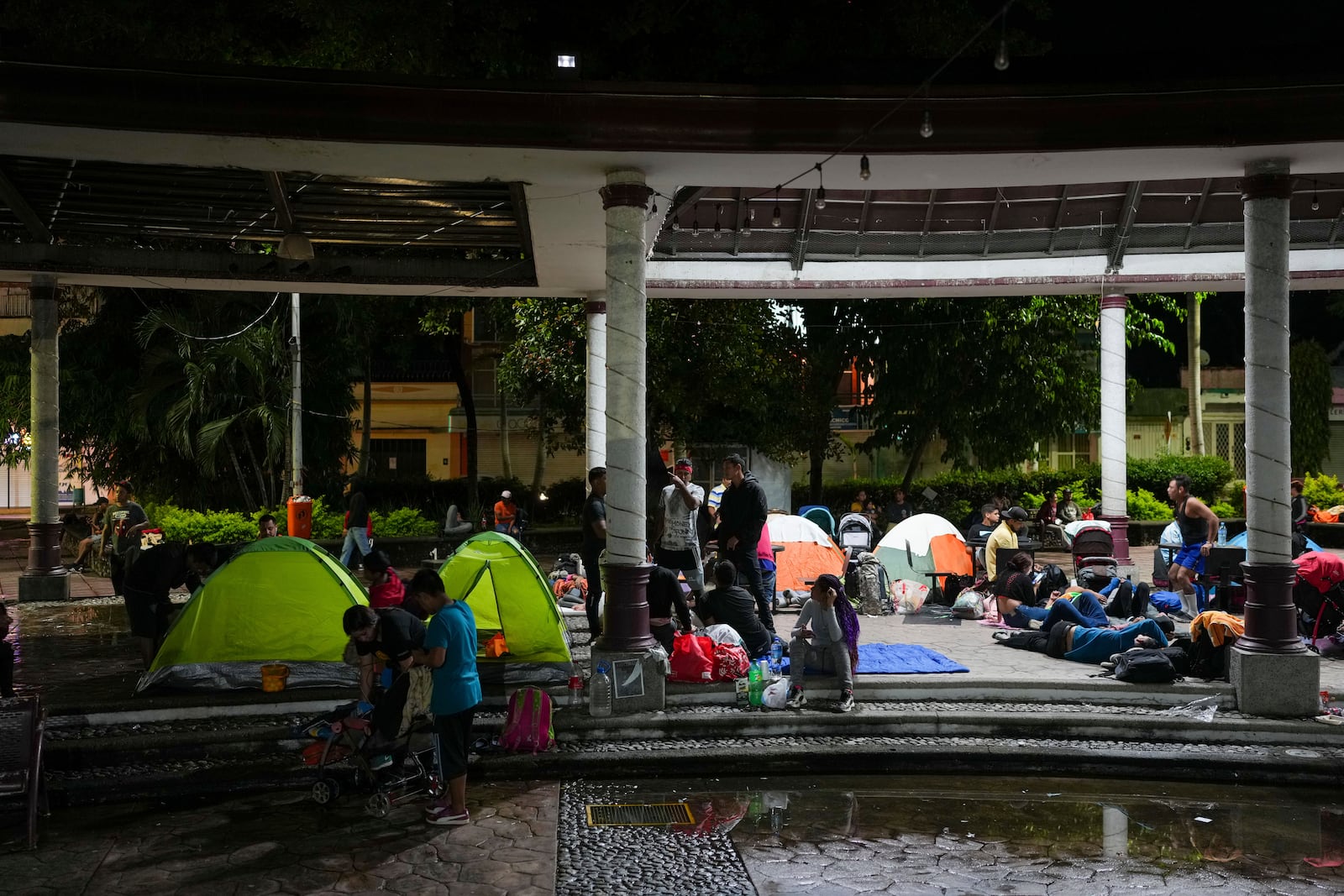 Migrants who are part of a caravan gather at Bicentenario Plaza in Tapachula, Mexico, Monday, Nov. 4, 2024, the night before departing by foot toward the U.S. border. (AP Photo/Moises Castillo)