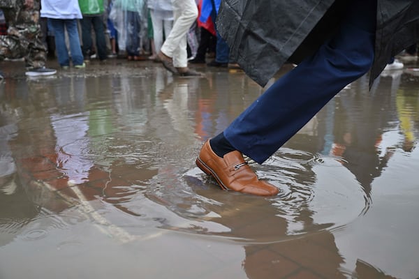 A race fan walks through a puddle at Churchill Downs before the 151st running of the Kentucky Derby horse race Saturday, May 3, 2025, in Louisville, Ky. (AP Photo/Jon Cherry)