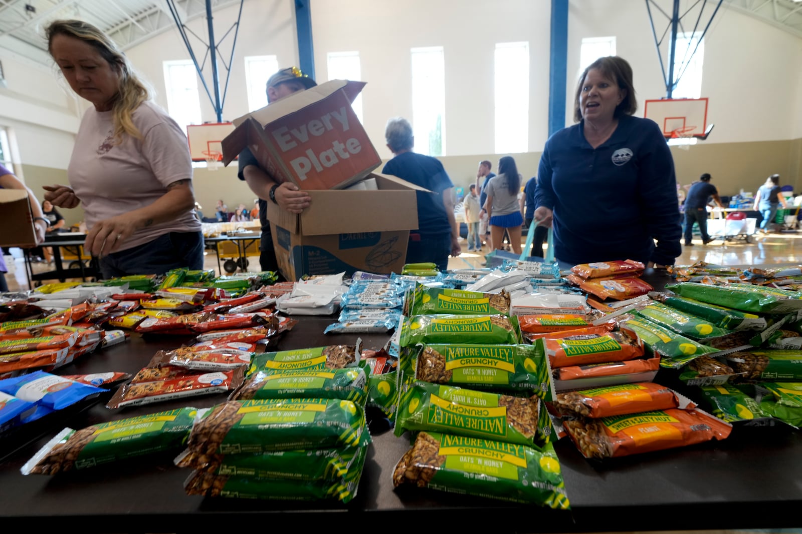 Victims load up on supplies at Watauga High School on Thursday, Oct. 3, 2024, in Boone, N.C. in the aftermath of hurricane Helene. In the final weeks of the presidential election, people in North Carolina and Georgia, influential swing states, are dealing with more immediate concerns: recovering from Hurricane Helene. (AP Photo/Chris Carlson)