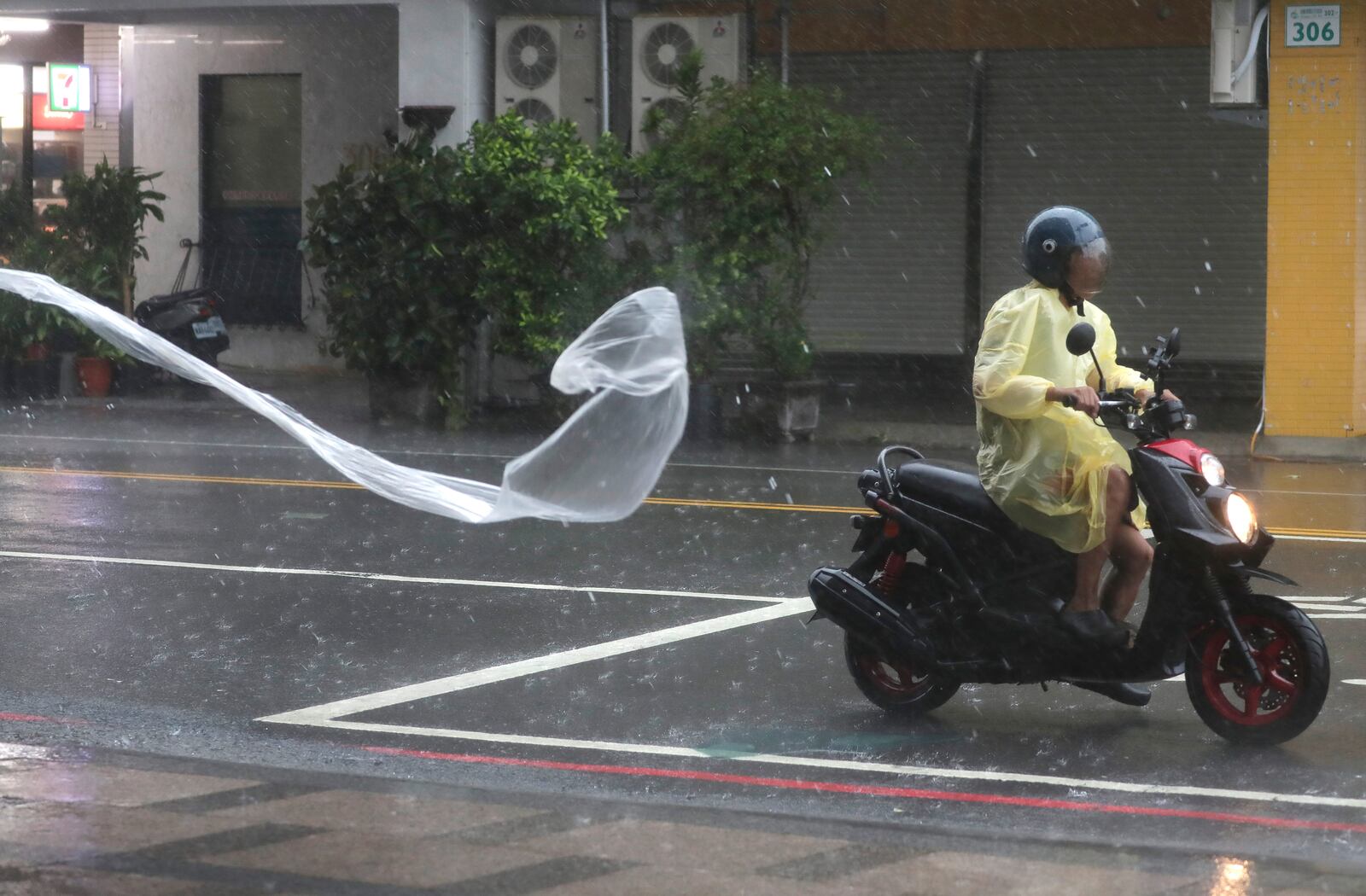 A man rides in the wind and rain generated by Typhoon Krathon in Kaohsiung, southern Taiwan, Thursday, Oct. 3, 2024. (AP Photo/Chiang Ying-ying)