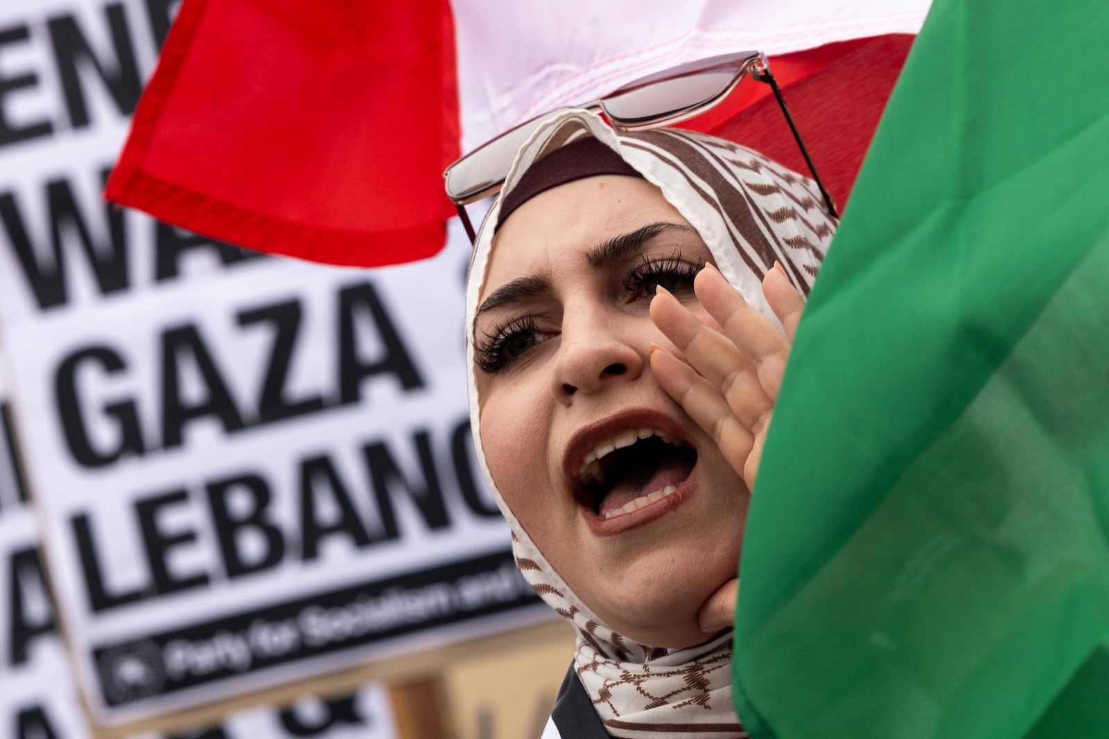 A protester waves a Lebanese flag as demonstrators gather to protest against the war on Gaza and Lebanon in front of the Los Angeles Federal Building on Tuesday, Sept. 24, 2024, in Los Angeles. (AP Photo/Etienne Laurent)