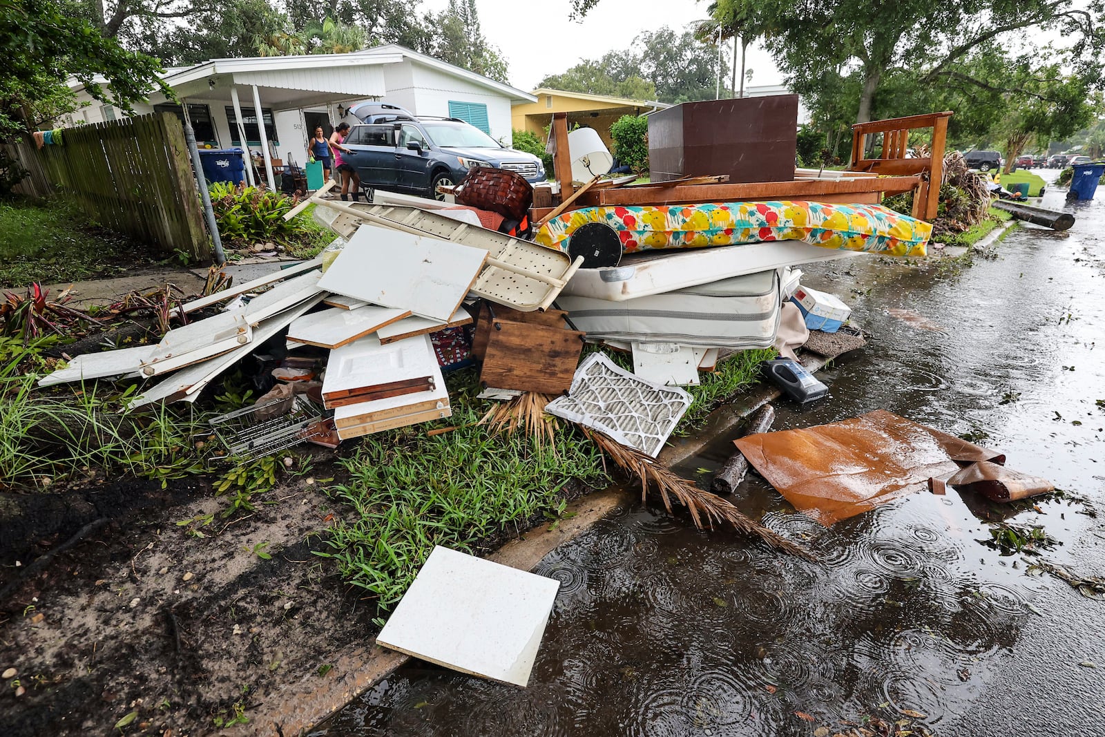 Residents clean contents of their home after flooding from Hurricane Helene on Davis Island Saturday, Sept. 28, 2024, in Tampa, Fla. (AP Photo/Mike Carlson)