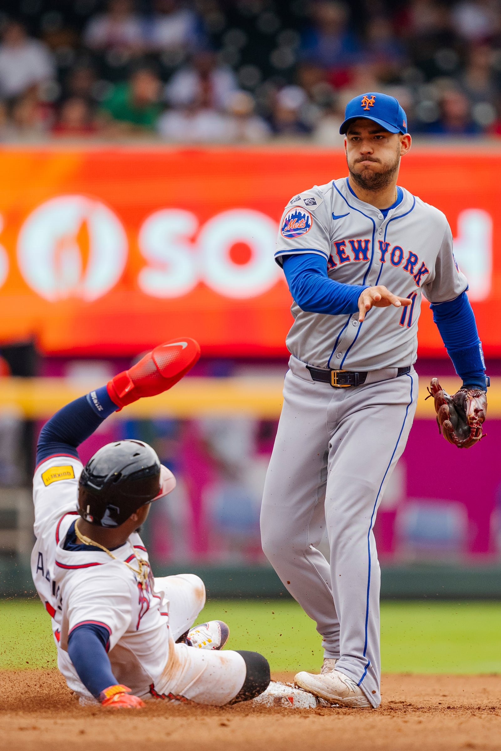 New York Mets second baseman Jose Iglesias, right, tags second base and throws to first before Atlanta Braves' Ozzie Albies, left, can slide into the bag in the fifth inning of a baseball game, Monday, Sept. 30, 2024, in Atlanta. (AP Photo/Jason Allen)