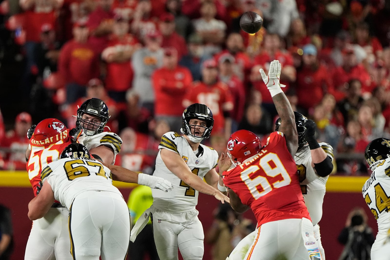 New Orleans Saints quarterback Derek Carr (4) throws over Kansas City Chiefs nose tackle Mike Pennel (69) during the first half of an NFL football game Monday, Oct. 7, 2024, in Kansas City, Mo. (AP Photo/Charlie Riedel)