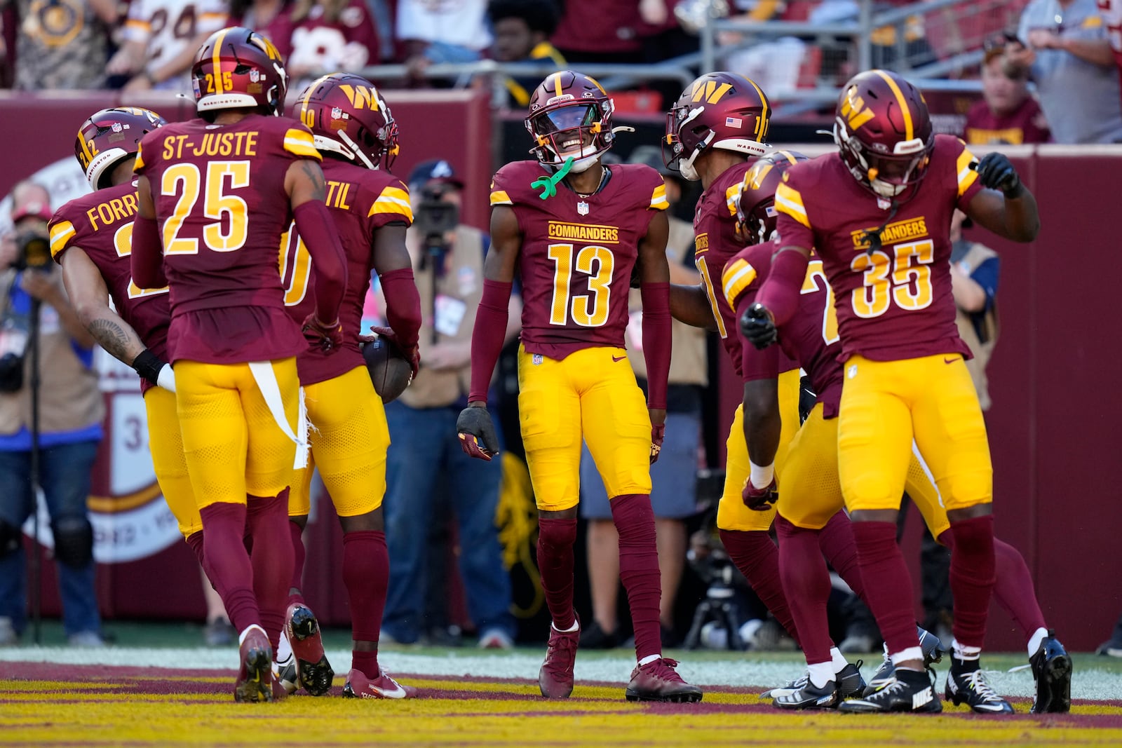 Washington Commanders cornerback Emmanuel Forbes Jr. (13) celebrates with teammates after intercepting a pass during the first half of an NFL football game against the Carolina Panthers, Sunday, Oct. 20, 2024, in Landover, Md. (AP Photo/Stephanie Scarbrough)