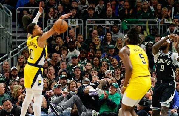 Milwaukee Bucks' Kevin Porter Jr. leaps into the crowd trying to save a ball against the Indiana Pacers during the first half of Game 4 of a first-round NBA basketball playoff series Sunday, April 27, 2025, in Milwaukee. (AP Photo/Jeffrey Phelps)