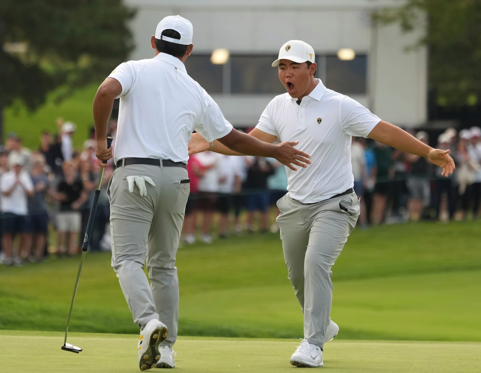 International team members Tom Kim, right, celebrates with partner Si Woo Kim, both of South Korea, after winning the 12th hole during the third round at the Presidents Cup golf tournament at Royal Montreal Golf Club in Montreal Saturday, Sept. 28, 2024. (Christinne Muschi/The Canadian Press via AP)