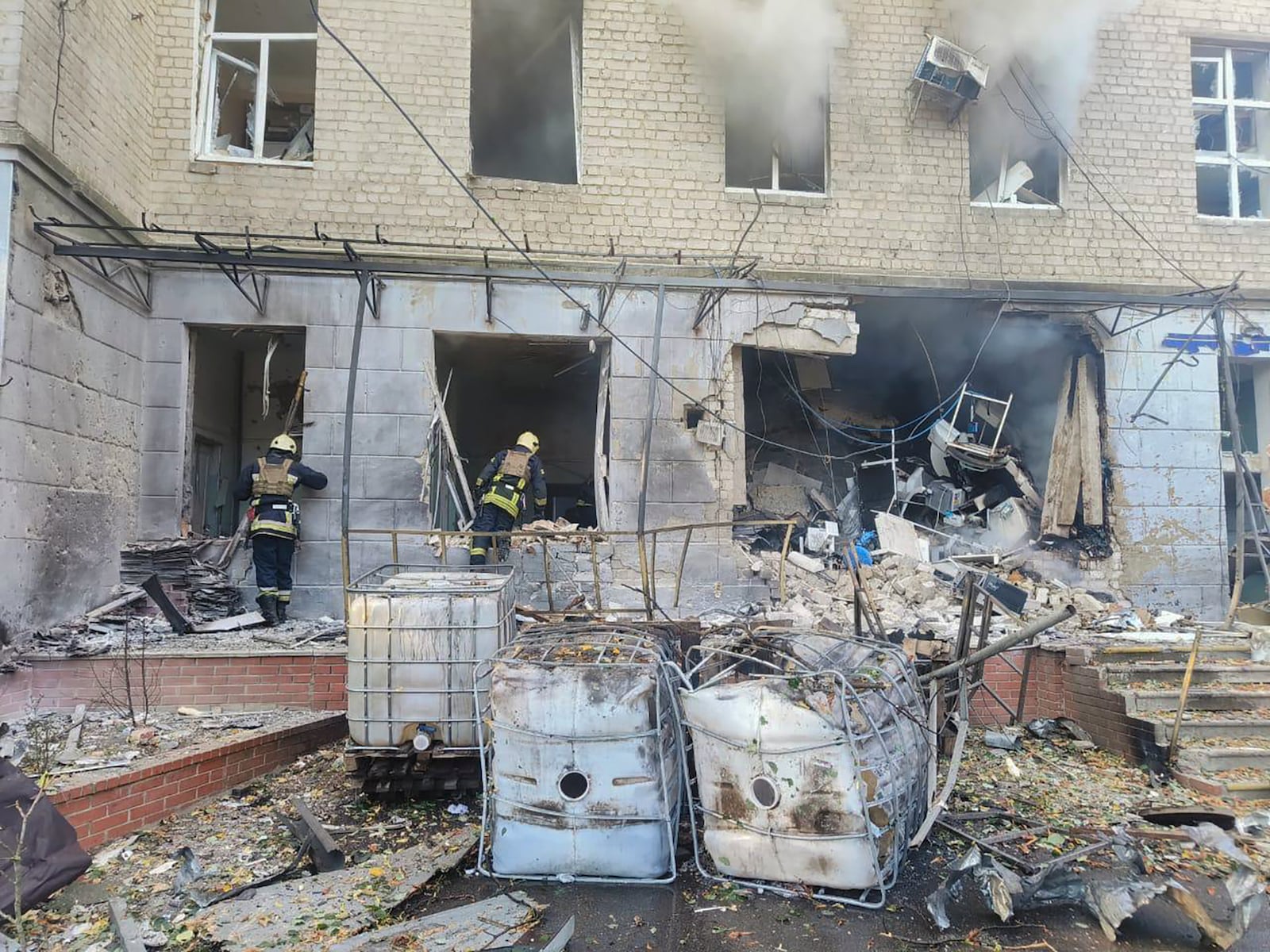 In this photo provided by the Ukrainian Emergency Service, emergency services workers look to move rubble and find injured after Russian attacks on a medical center in the northeastern Ukrainian city of Sumy Saturday, Sept. 28, 2024. (Ukrainian Emergency Service via AP)