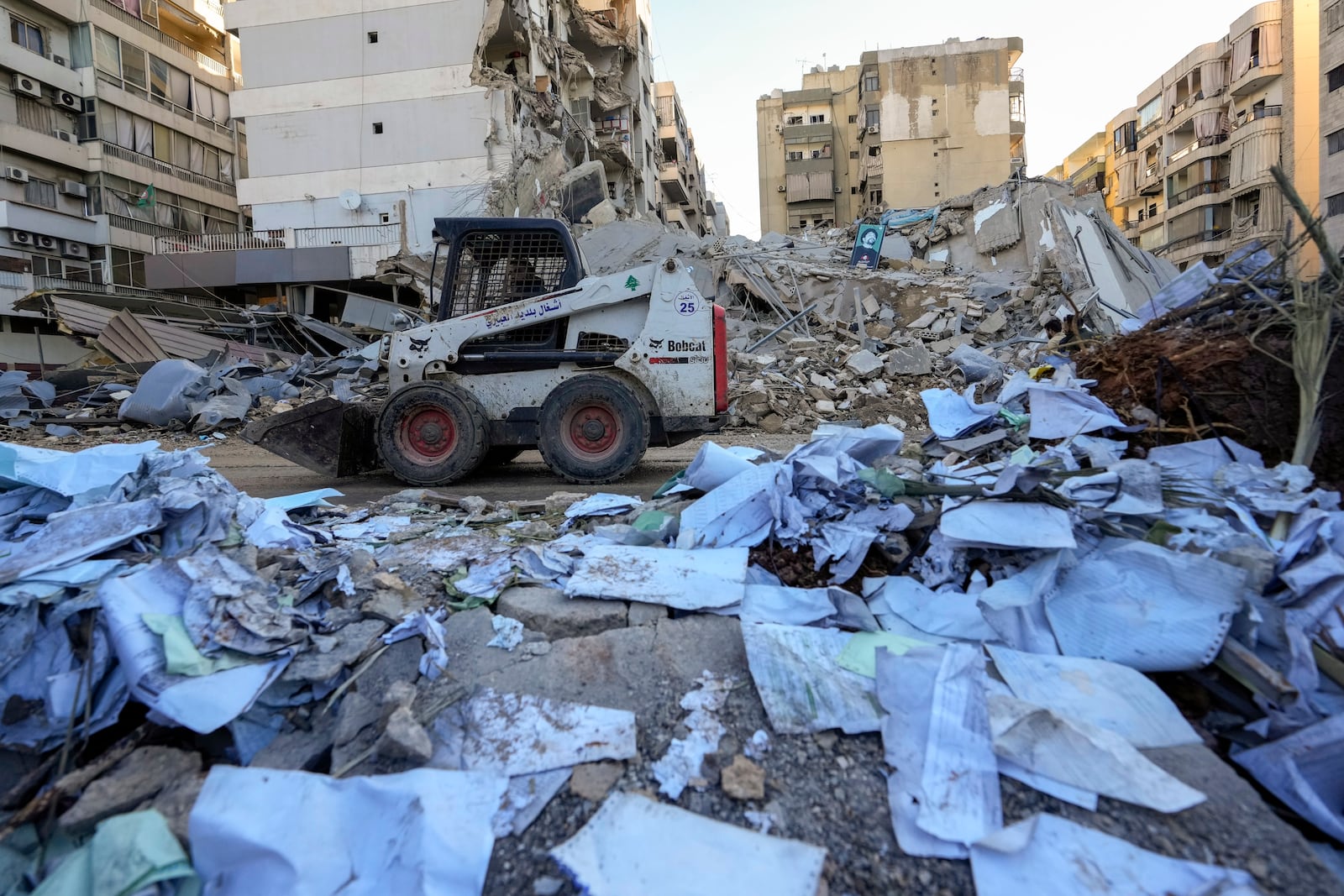 Documents of Hezbollah-run al-Qard al-Hassan are scattered at the site of an Israeli airstrike on Sunday night in Beirut's southern suburb, Lebanon, Monday, Oct. 21, 2024. (AP Photo/Hassan Ammar)