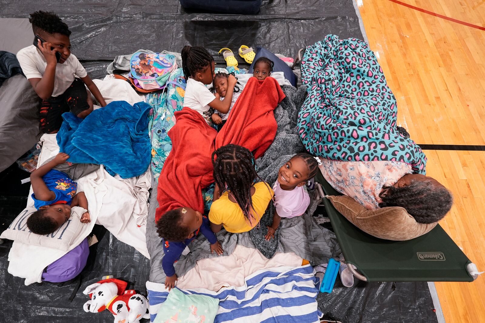 Vera Kelly, of Tallahassee, lies on a cot after evacuating to a hurricane shelter with her grandchildren and great grandchildren, at Fairview Middle School, ahead of Hurricane Helene, expected to make landfall here today, in Leon County, Fla., Thursday, Sept. 26, 2024. (AP Photo/Gerald Herbert)