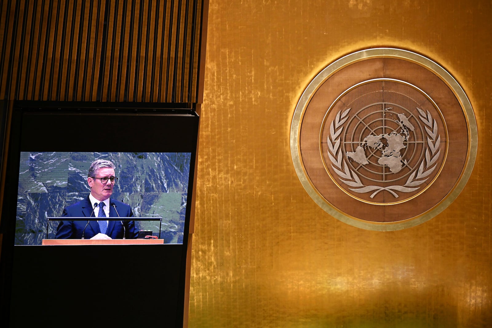 Britain's Prime Minister Keir Starmer viewed on a screen above as he addresses in person below to the 79th session of the United Nations General Assembly, Thursday, Sept. 26, 2024, at U.N. headquarters. (Leon Neal/Pool Photo via AP)