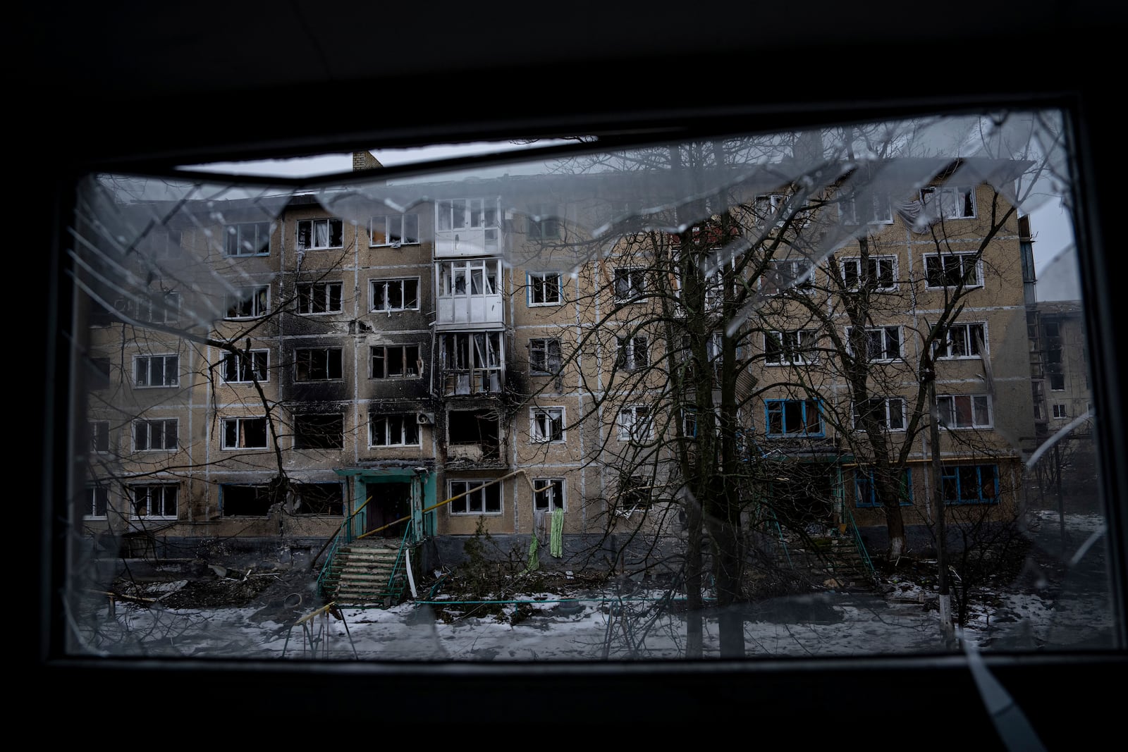 FILE - A residential building which was destroyed by Russian forces is seen through the broken window, in the frontline city of Vuhledar, Ukraine, Feb. 25, 2023. (AP Photo/Evgeniy Maloletka, File)