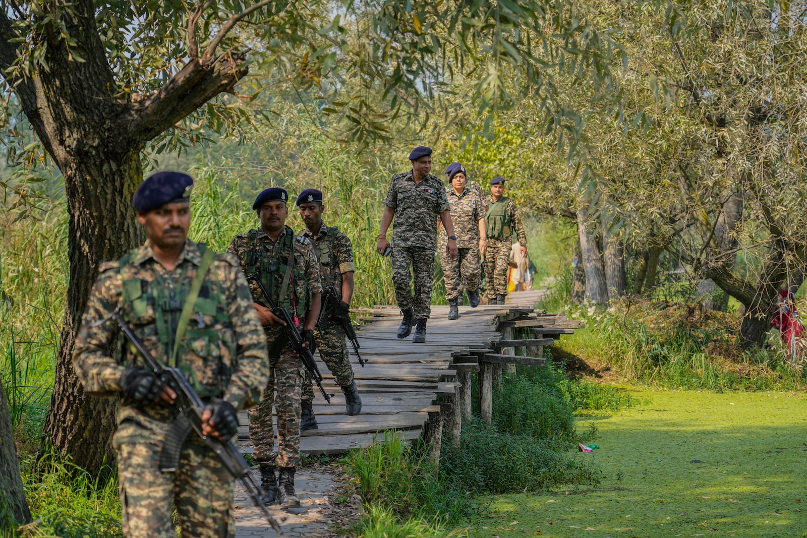 Indian soldiers walk on a wooden bridge on patrol during the second phase of the assembly election inside the interior of Dal Lake in Srinagar, Indian controlled Kashmir, Wednesday, Sept. 25, 2024. (AP Photo/Mukhtar Khan)