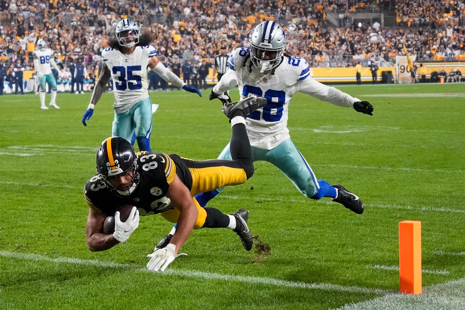 Pittsburgh Steelers tight end Connor Heyward (83) dives in for a touchdown after making a catch in front of Dallas Cowboys safety Malik Hooker (28) and linebacker Marist Liufau (35) during the second half of an NFL football game, Sunday, Oct. 6, 2024, in Pittsburgh. (AP Photo/Gene J. Puskar)