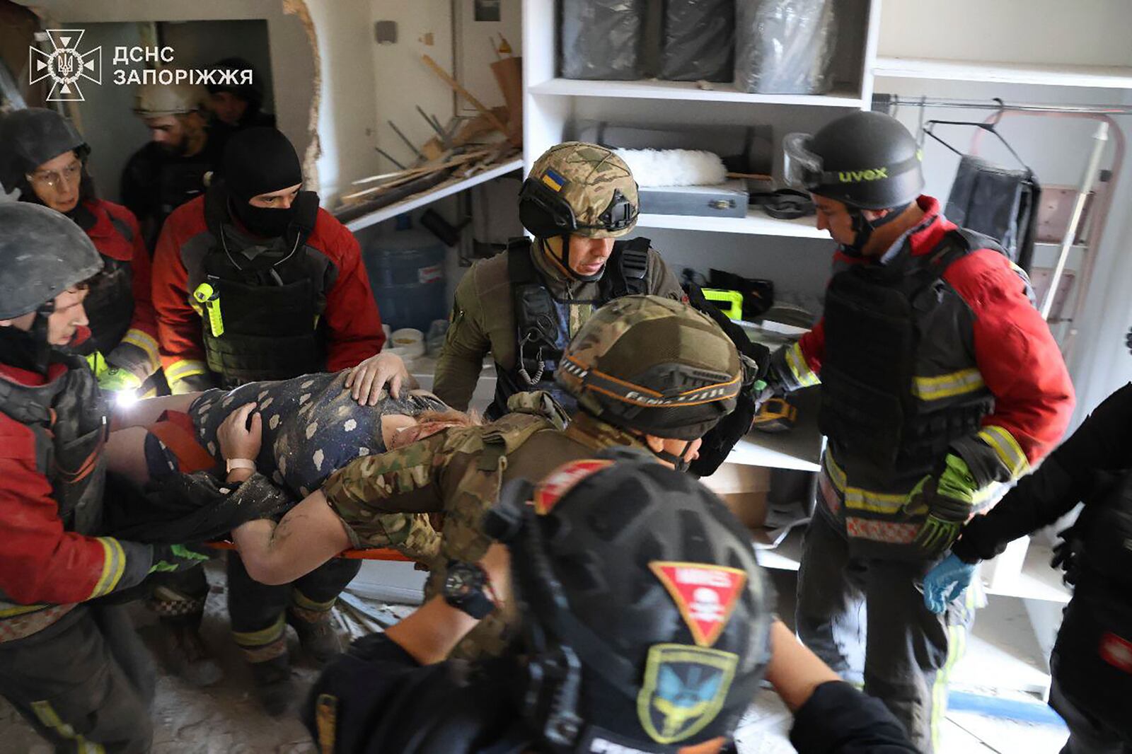 In this photo provided by the Ukrainian Emergency Service, rescuers evacuate a resident of apartment houses after Russia attacked the city with guided bombs overnight in Zaporizhzhia, Ukraine, Sunday, Sept. 29, 2024. (Ukrainian Emergency Service via AP)