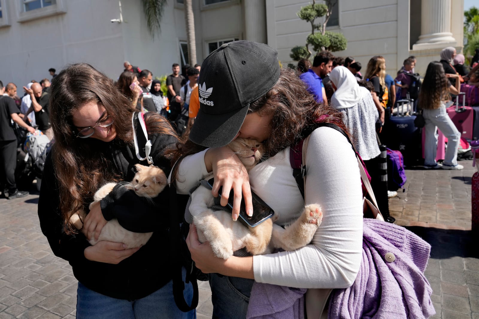 Turkish citizens carry their cats as they wait to board a Turkish navy vessel to be evacuated to Turkey at a gathering point, in Beirut, Lebanon, Wednesday, Oct. 9, 2024. (AP Photo/Hussein Malla)