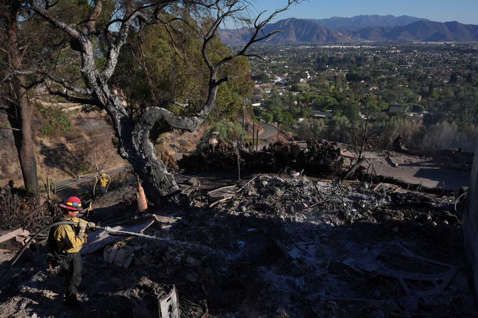 A Los Angeles Fire Department firefighter works at a home destroyed by the Mountain Fire in Camarillo, Calif., Friday, Nov. 8, 2024. (AP Photo/Jae C. Hong)