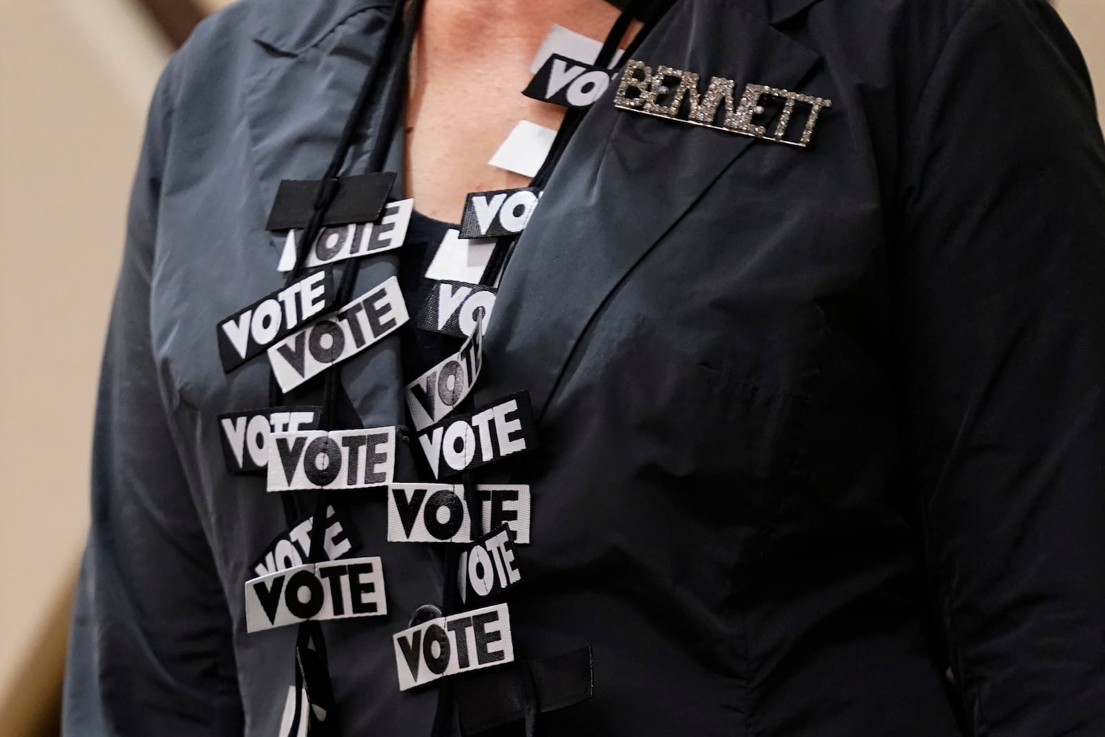 Bennett College President Suzanne Elise Walsh wears a necklace covered with vote signs during a roundtable in Greensboro, N.C., Tuesday, Oct. 8, 2024. (AP Photo/Chuck Burton)