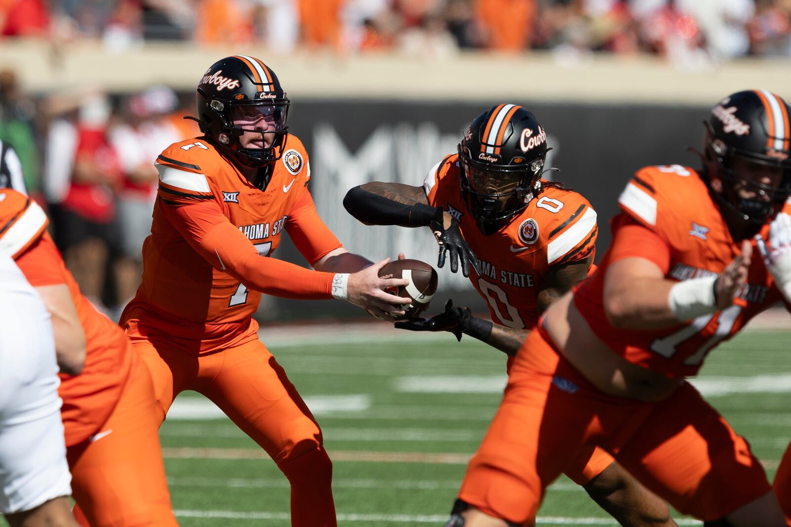 Oklahoma State quarterback Alan Bowman (7) hands the ball off to running back Ollie Gordon II (0) in the first half of an NCAA college football game against Utah Saturday, Sept. 21, 2024, in Stillwater, Okla. (AP Photo/Mitch Alcala)