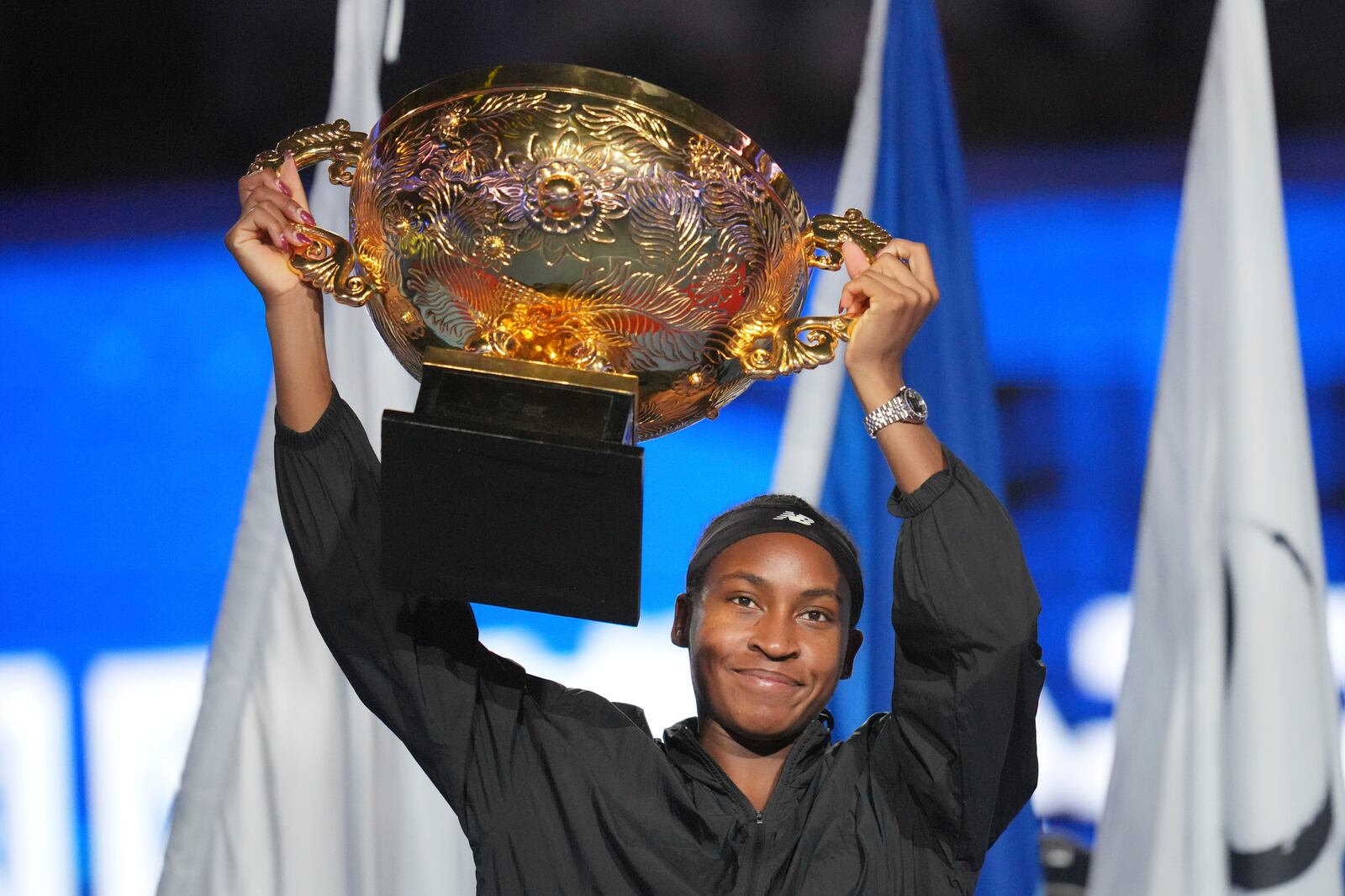 Coco Gauff of the United States celebrates with the championship trophy after defeating Karolina Muchova of Czech Republic in the women's singles final match at the China Open tennis tournament at the National Tennis Center in Beijing, Sunday, Oct. 6, 2024. (AP Photo/Achmad Ibrahim)